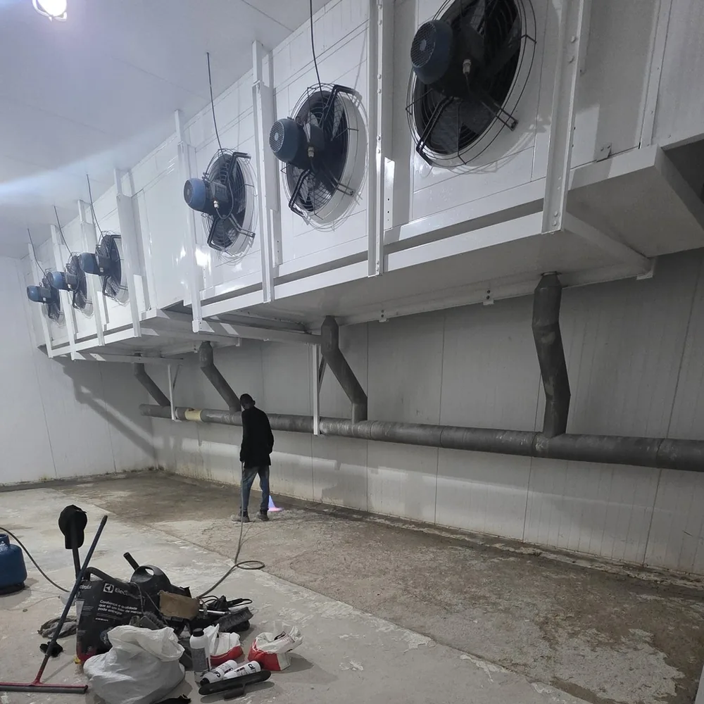 Túnel de congelamento com o piso de concreto exposto, sujo e sem revestimento, antes da obra